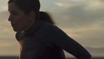 a woman standing in front of a cloudy sky