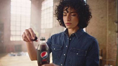 a woman holding a soda bottle in her right hand