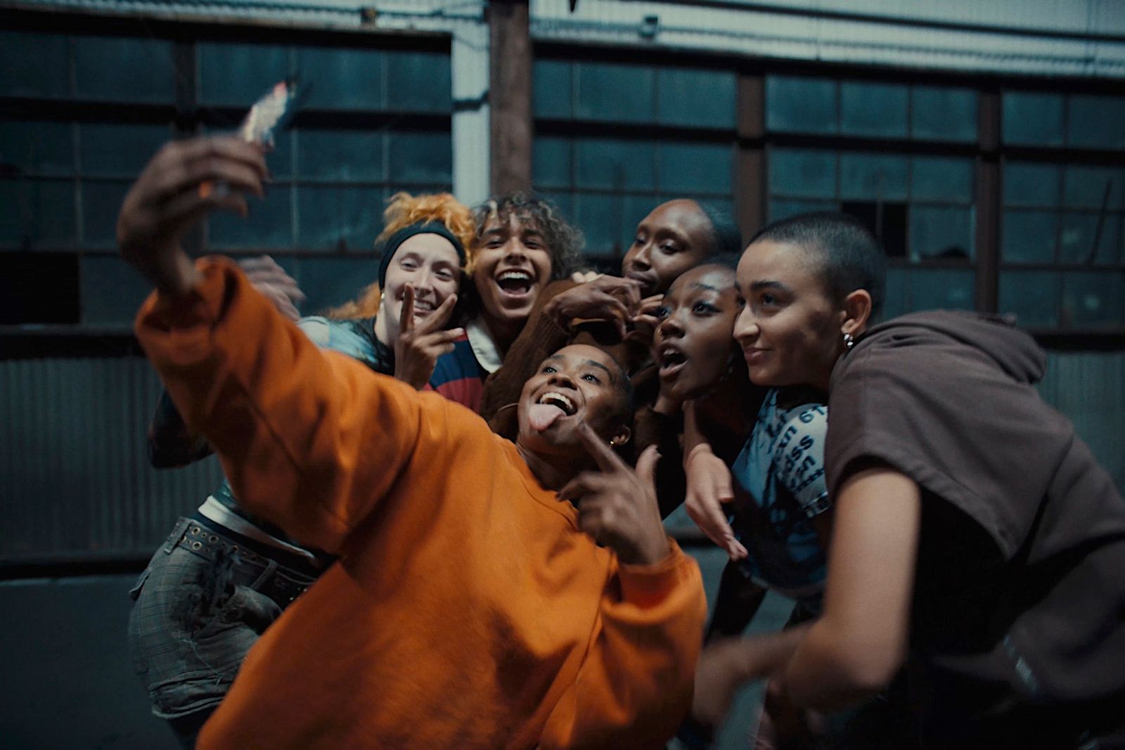 a group of people taking a picture with a cell phone