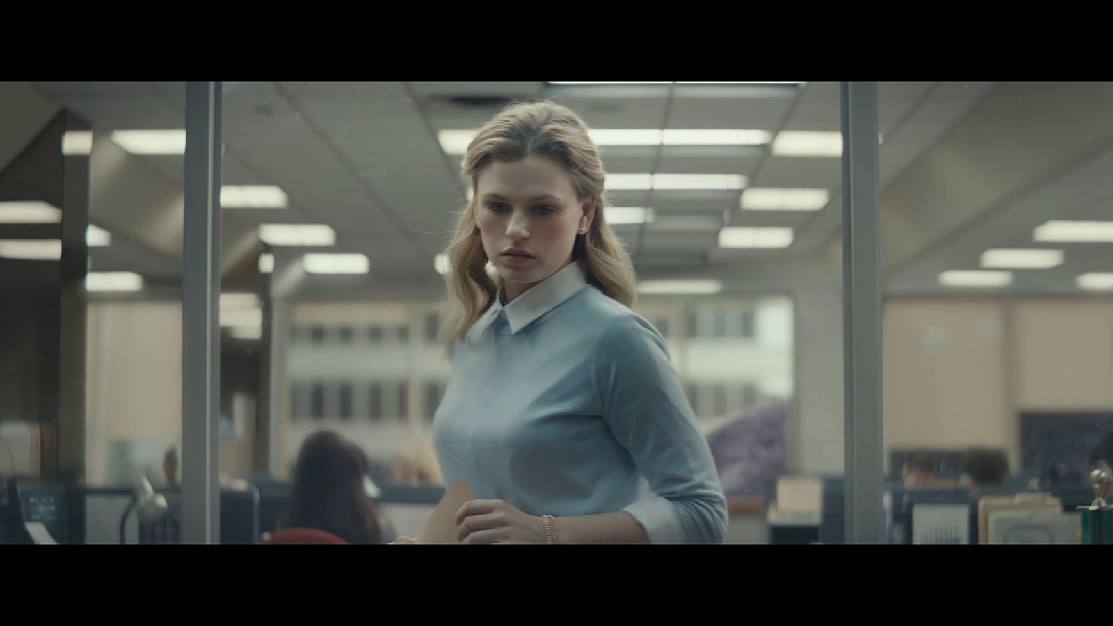 a woman standing in an office looking at the camera