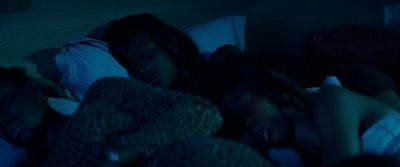 a couple of people laying in a bed in the dark