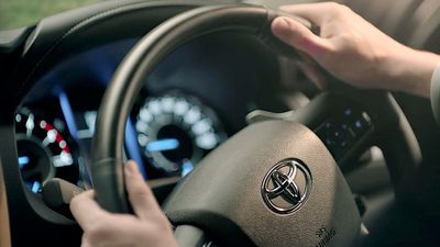 a person holding the steering wheel of a car