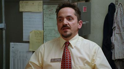 a man in a dress shirt and tie standing in an office