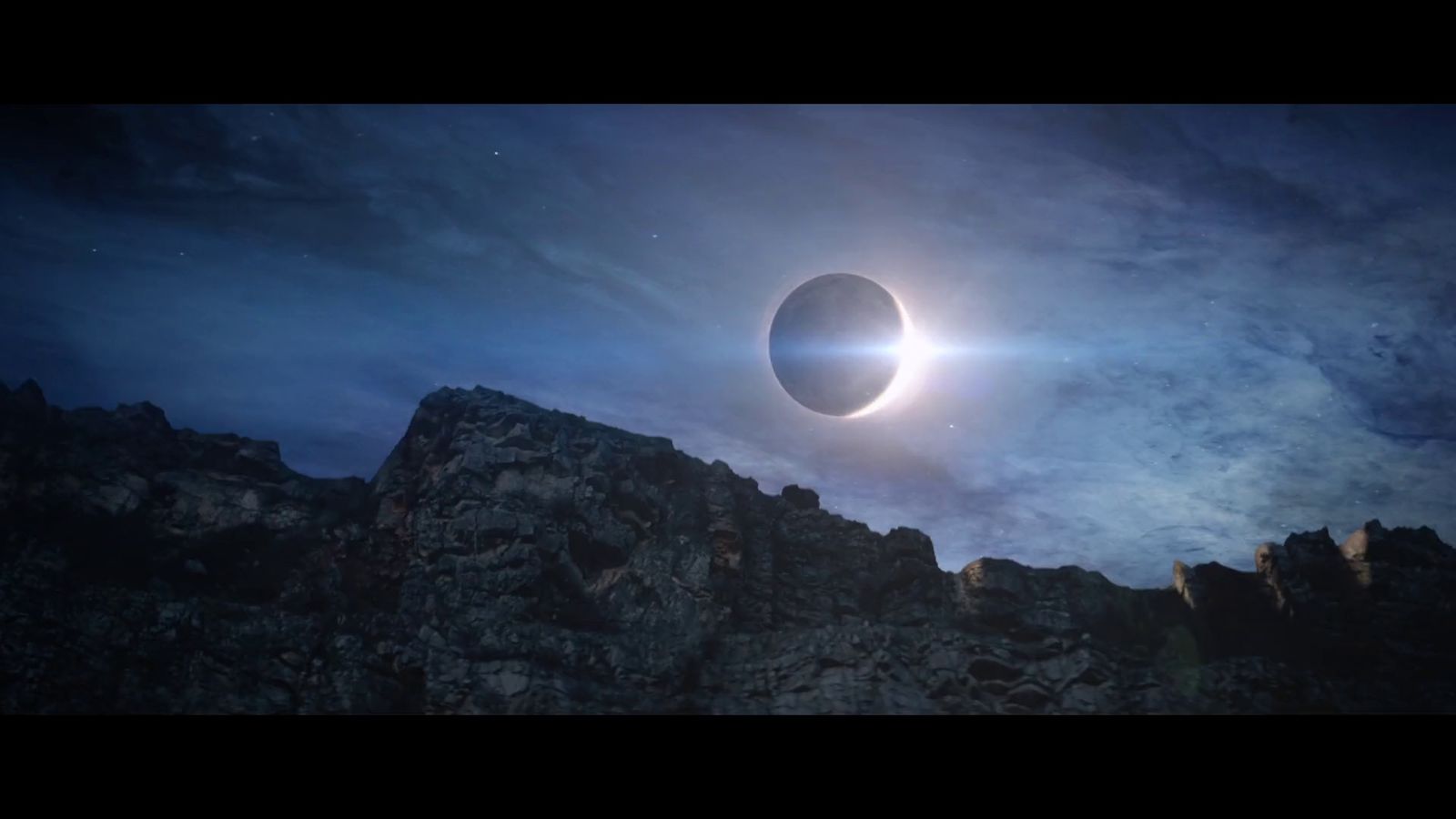 a solar eclipse is seen over a rocky mountain range