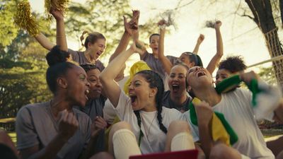 a group of people sitting on the ground with their hands in the air