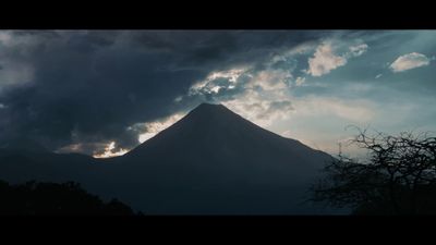 a large mountain with clouds in the sky