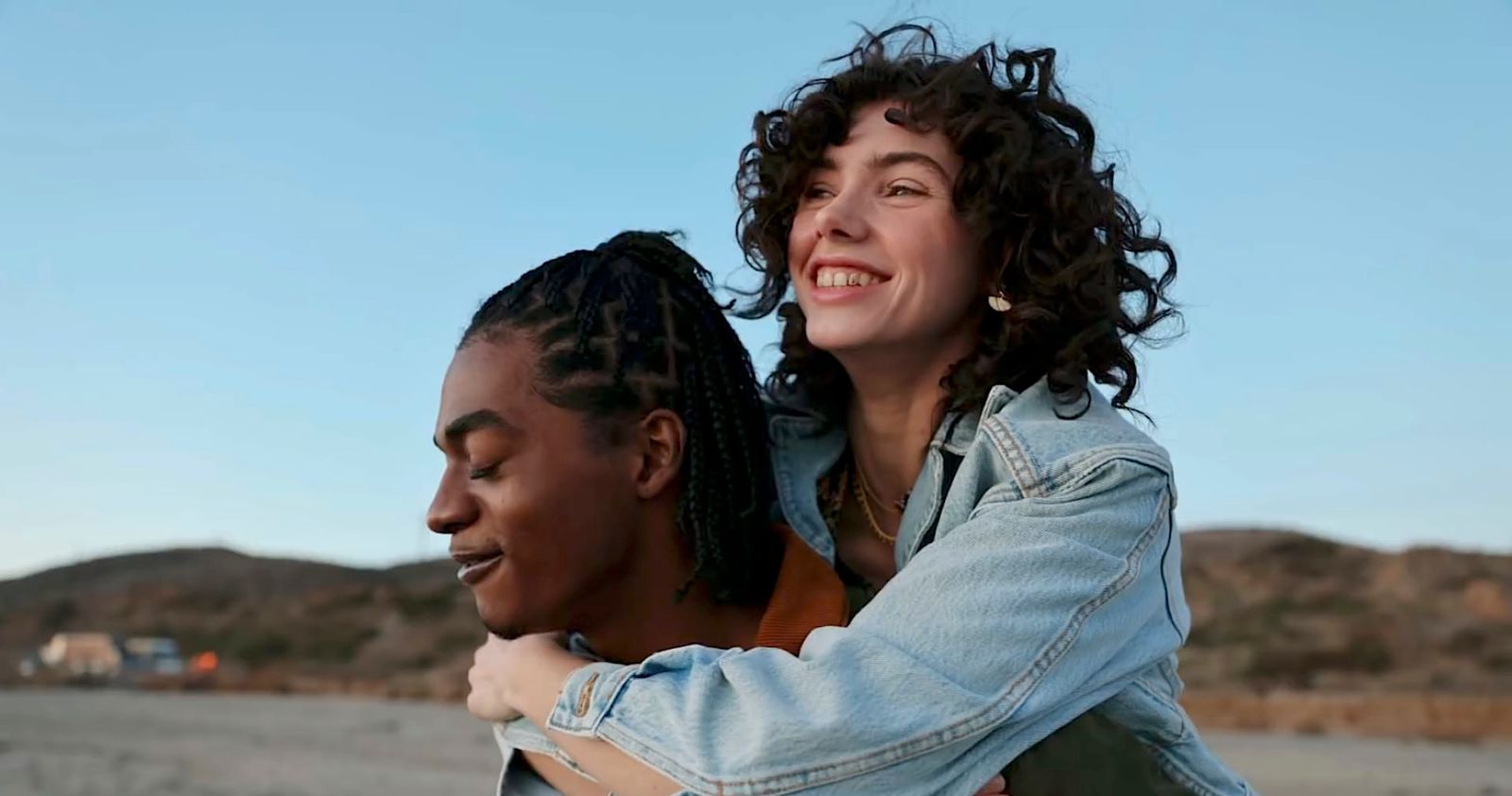 a woman is hugging a man in the desert