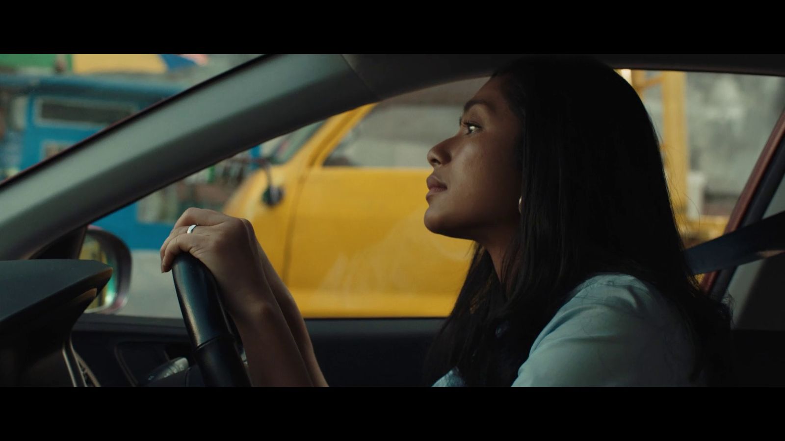 a woman sitting in a car looking out the window