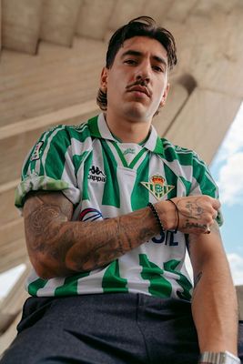 a man with tattoos sitting on a bench