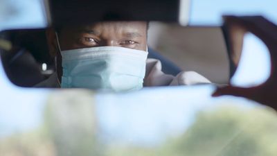 a man in a car wearing a face mask