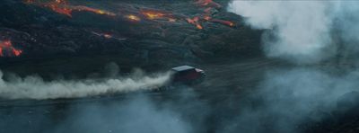 an aerial view of a volcano with smoke coming out of it