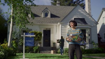 a woman standing in front of a house