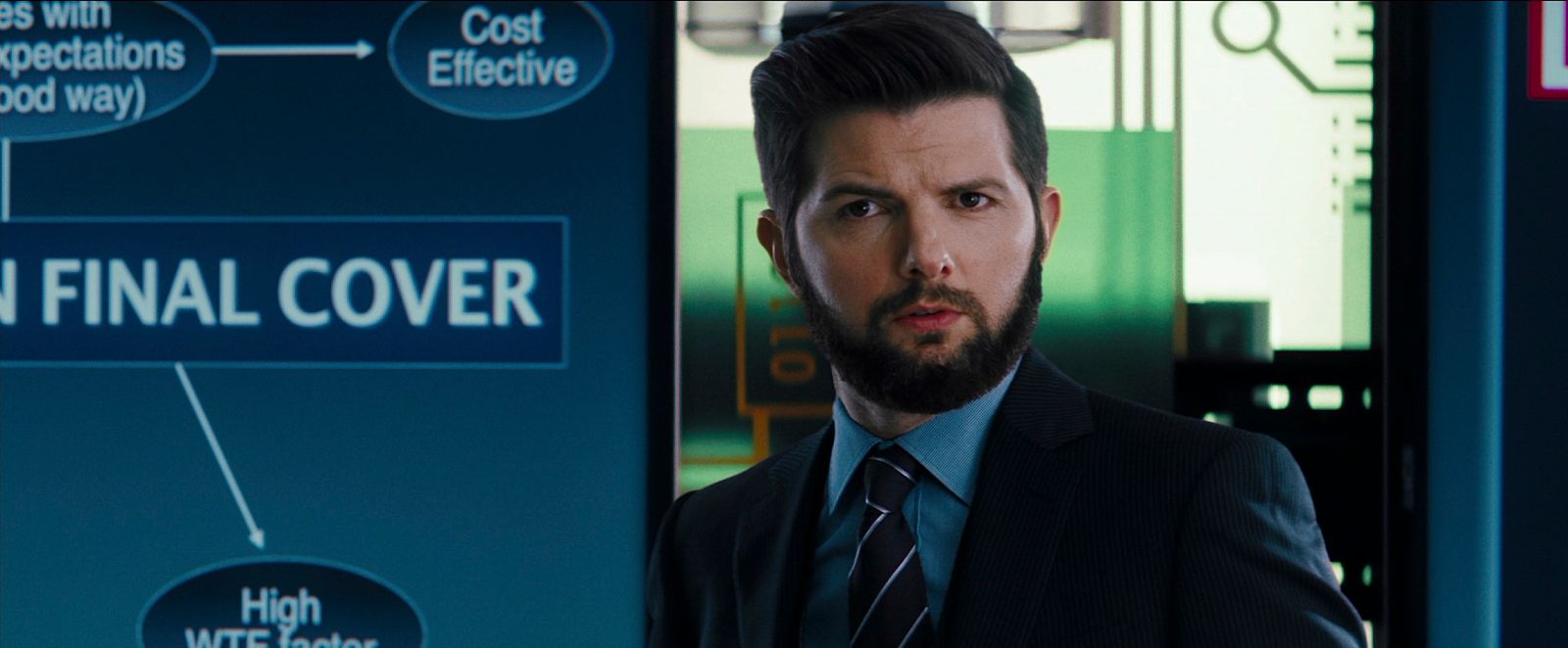 a man in a suit and tie standing in front of a sign