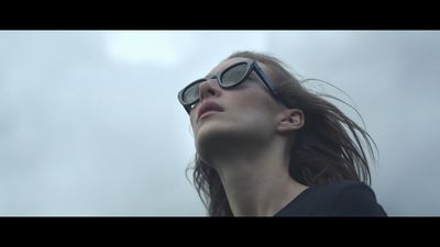 a woman wearing sunglasses looking up into the sky