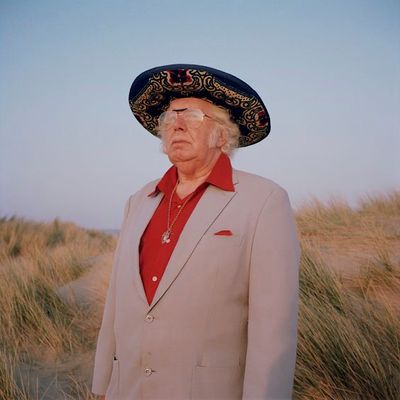 an old man wearing a sombrero and a red shirt