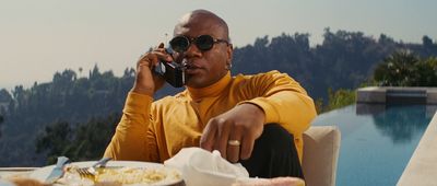 a man sitting at a table talking on a cell phone