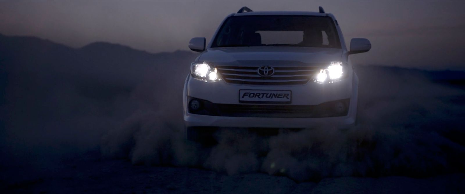 a white car driving down a dirt road