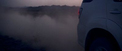 a car driving on a foggy road at night