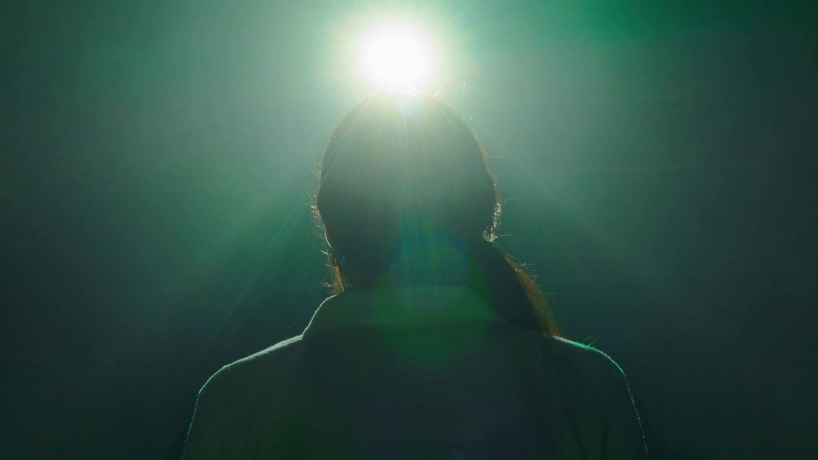 a person standing in front of a green light