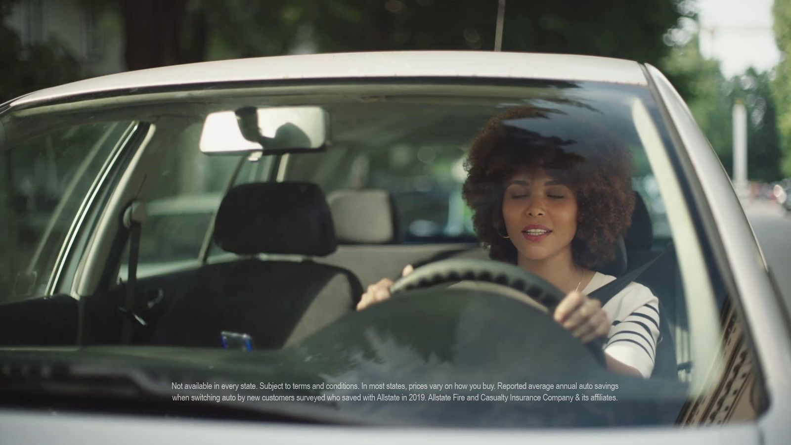 a woman driving a car on a city street