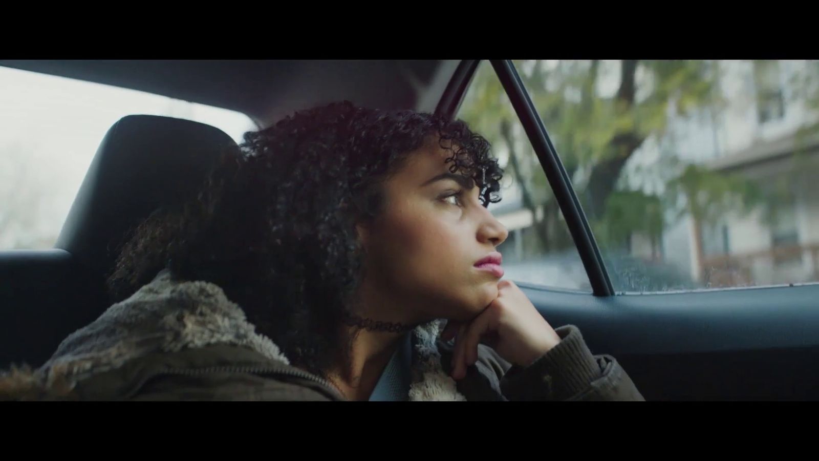 a woman sitting in a car looking out the window