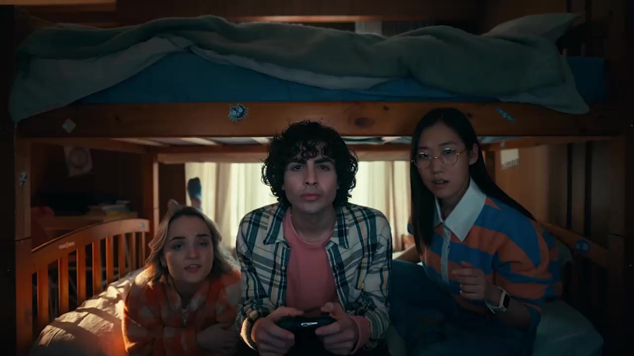 a group of people sitting on top of a bunk bed