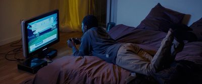 a person laying on a bed in front of a tv