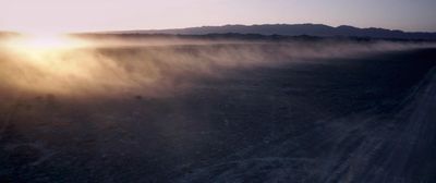 the sun is shining through the clouds in the desert