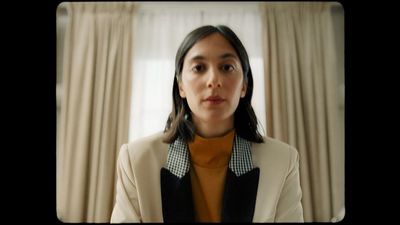 a woman wearing a white jacket and black collar