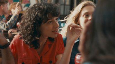 a woman sitting at a table talking to another woman