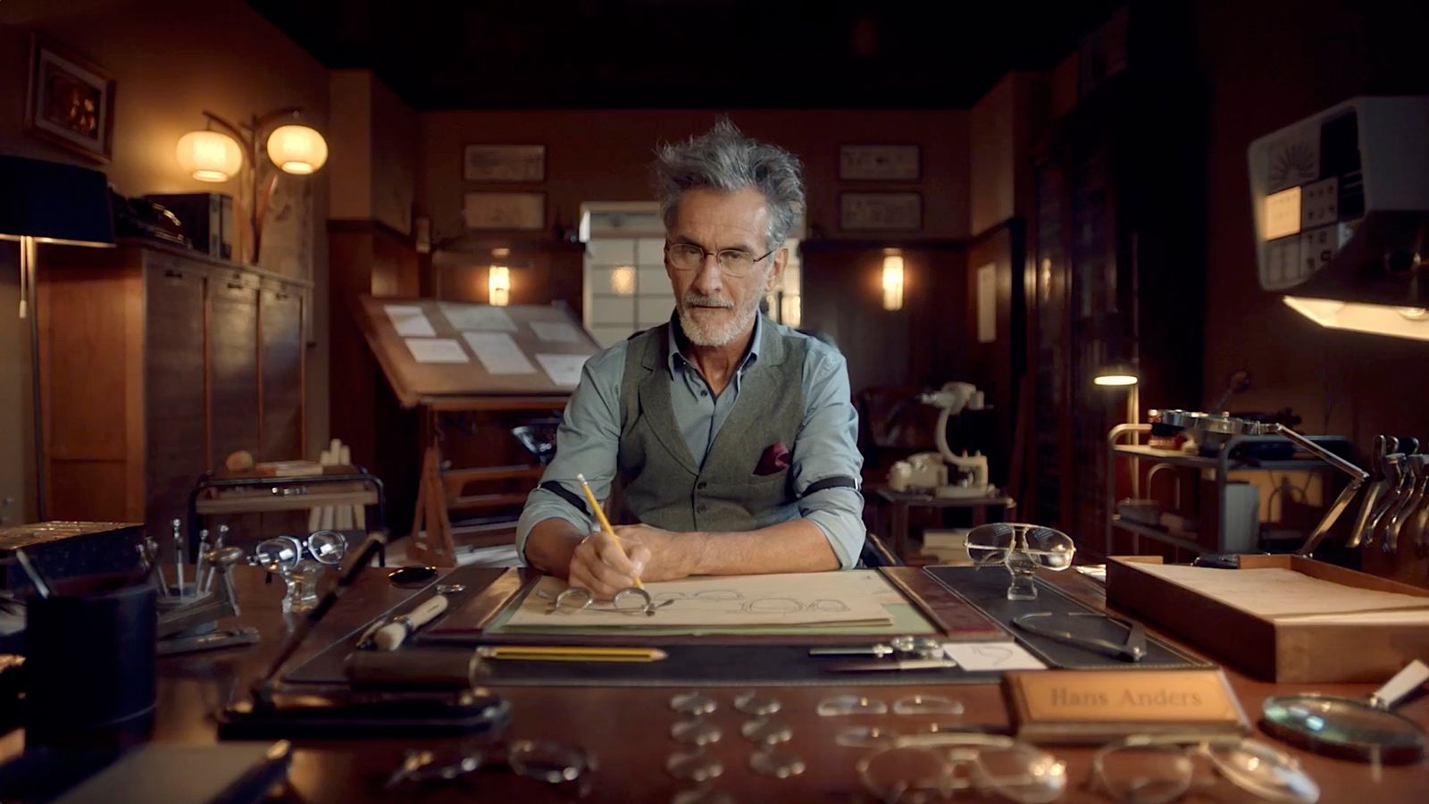 a man sitting at a desk writing on a piece of paper