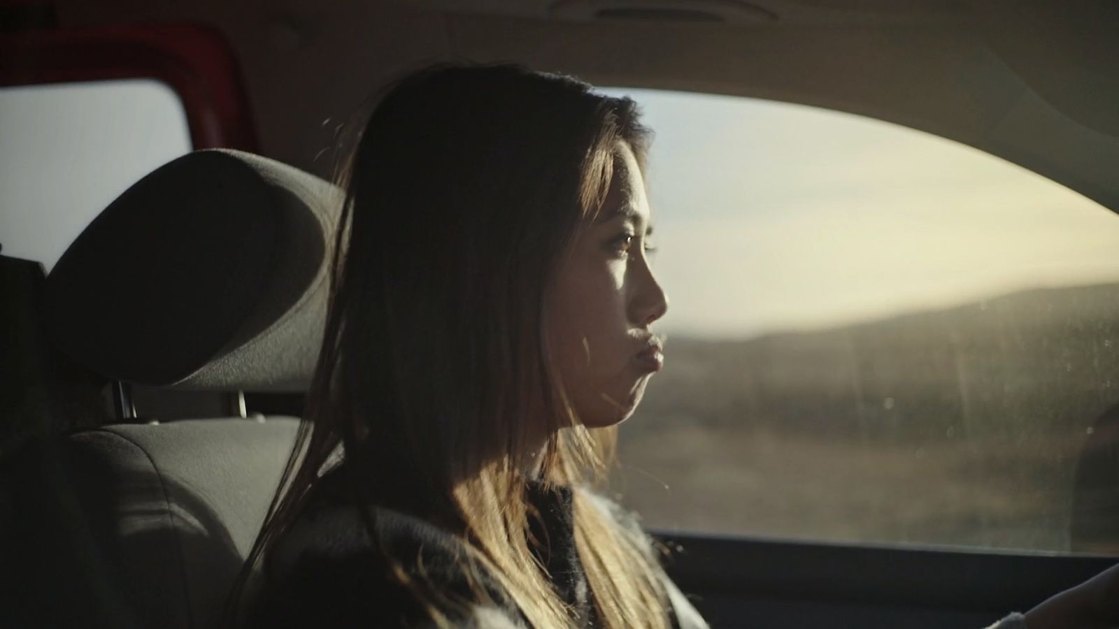 a woman sitting in a car looking out the window