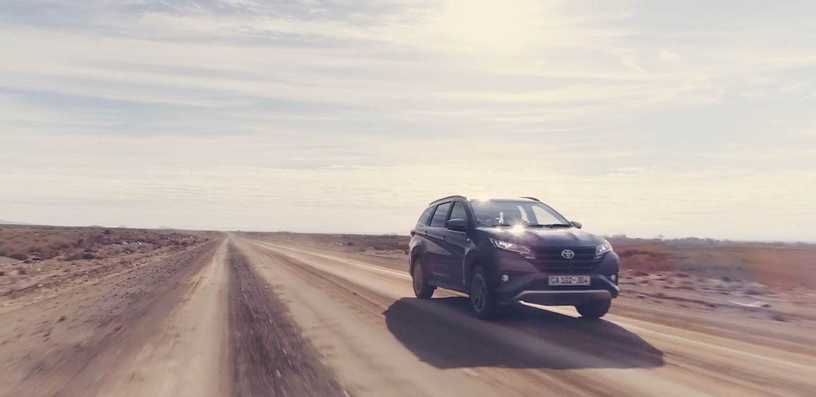 a car driving down a dirt road in the desert