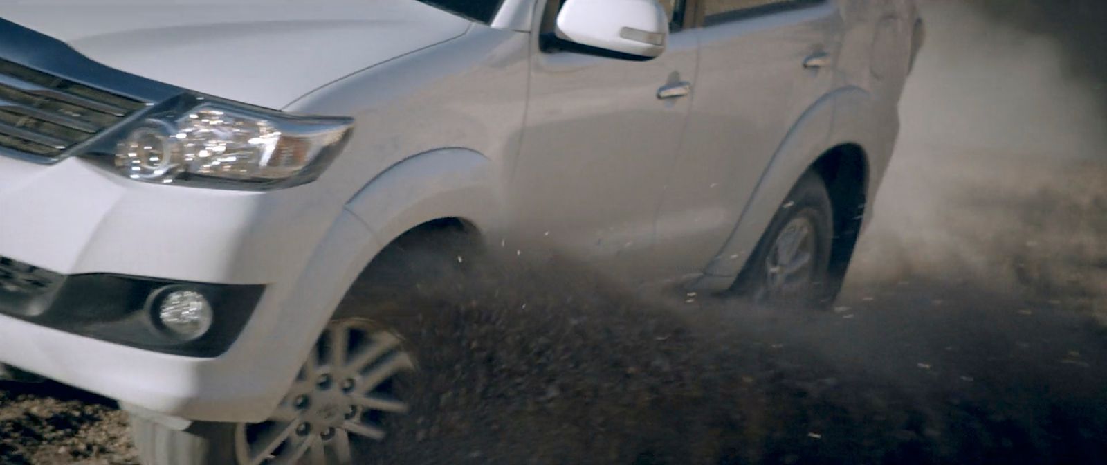 a white truck driving down a dirt road