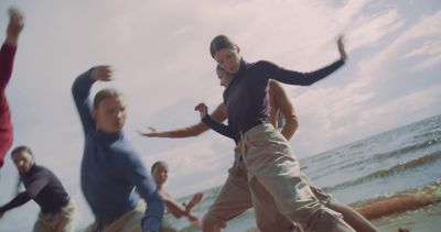 a group of people running on the beach