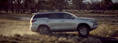 a silver toyota suv driving through a field