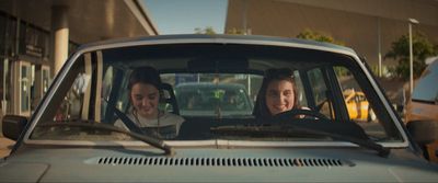 two women sitting in a car talking to each other