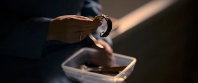 a person holding a pair of scissors in a plastic container