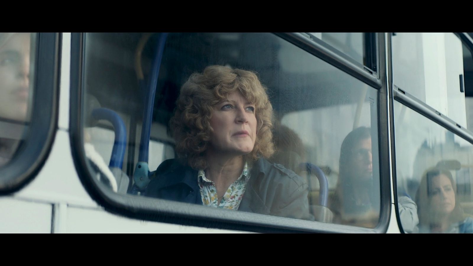 a woman looking out the window of a bus