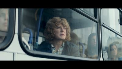 a woman looking out the window of a bus