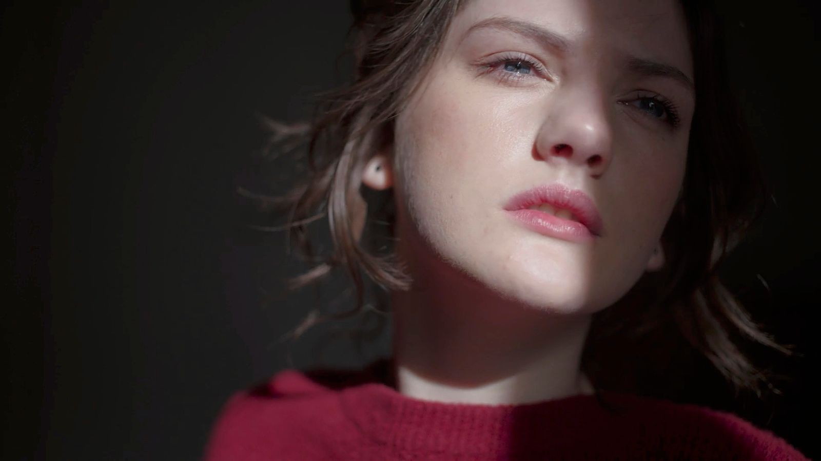 a close up of a person wearing a red sweater