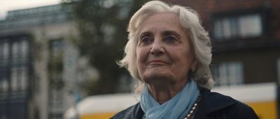 a woman in a black jacket and a blue scarf