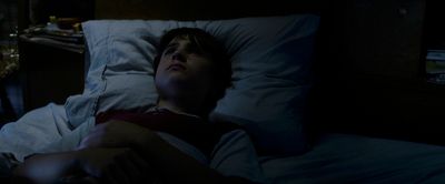 a person laying in a bed in the dark