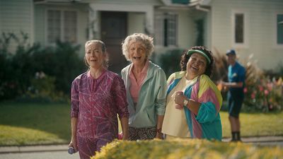 a group of women standing next to each other in front of a house