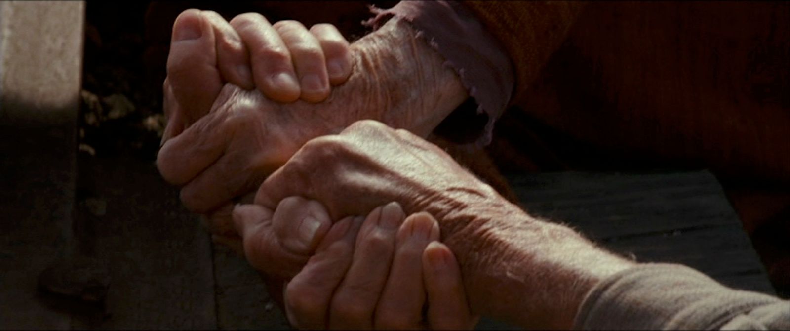 an older person holding the hand of a younger person