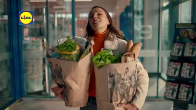 a woman holding a bag full of vegetables