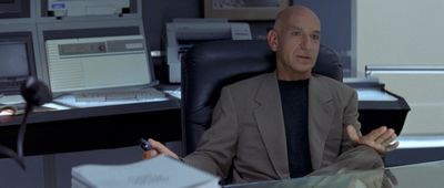 a bald man sitting at a desk in front of a computer