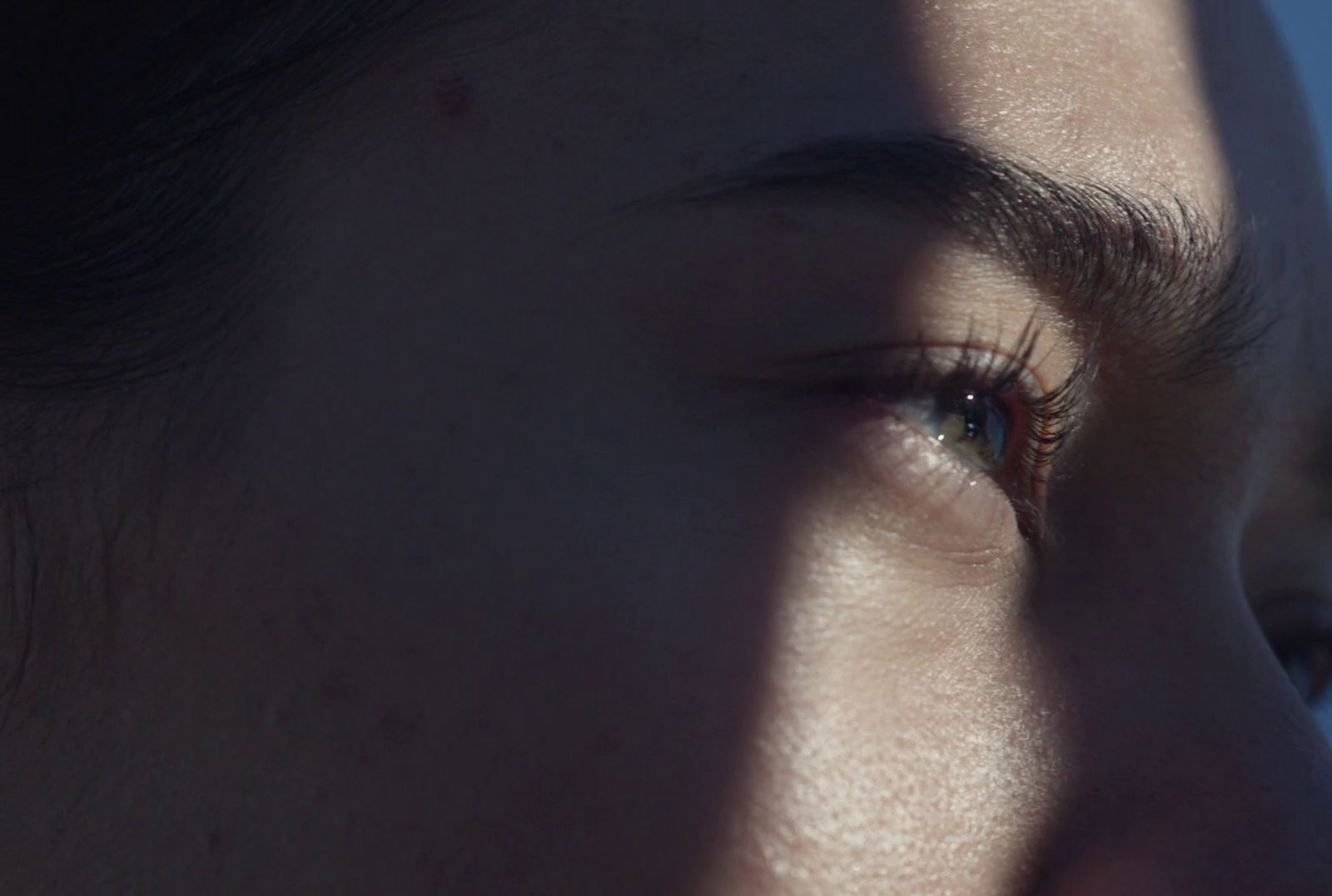 a close up of a person's face with a blue sky in the background