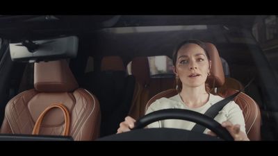 a woman driving a car with a steering wheel