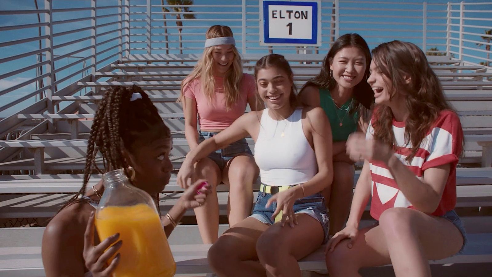 a group of girls sitting on a bench next to each other